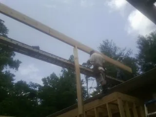 Carpenter setting a ridge beam over a new addition frame — Ice Dam Removal by Roofing Brothers in Pine Plains