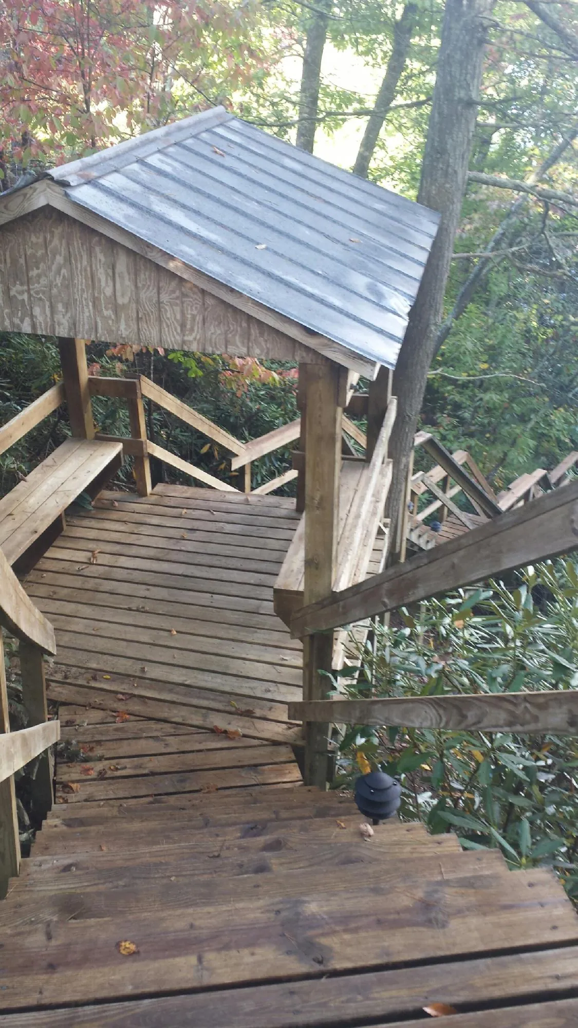 Metal roofed shelter over wooden steps on a wooded walkway — Skylight Repair & Installation work by our crew in Pine Plains