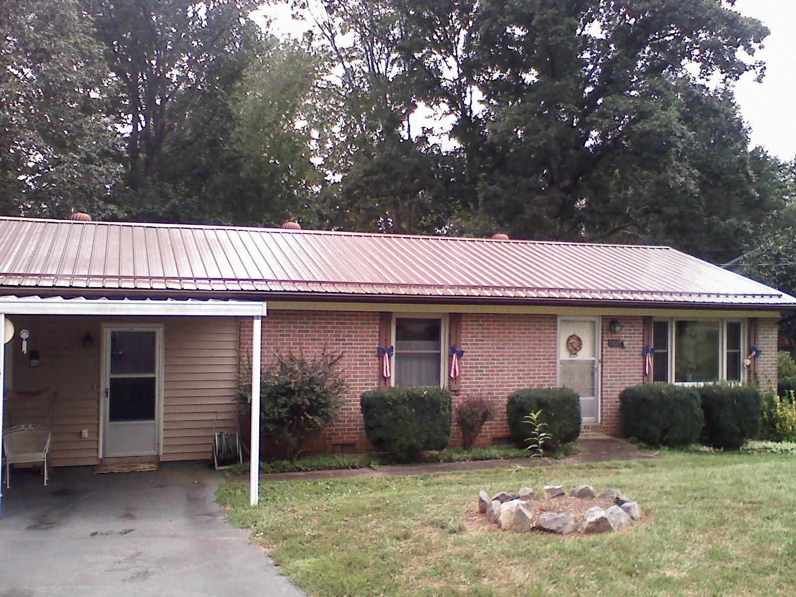 Bronze metal roof and carport on a brick ranch home — Roof Repair work by our crew in Pine Plains